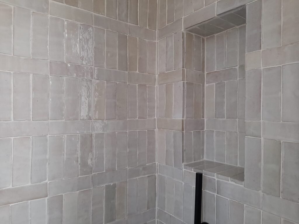 Ducha revestida con zellige blanco roto en formato rectangular Bejemat colocado en vertical, con hornacina
